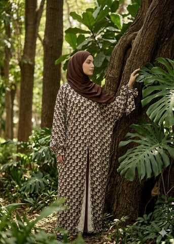 Woman in a patterned CrepeLoom dress and hijab standing in a forest