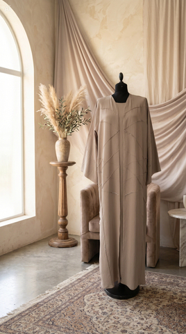 Beige dress on a mannequin in a room with draped fabric and a window.