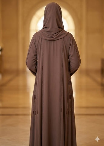 Person wearing a brown abaya with a blurred background