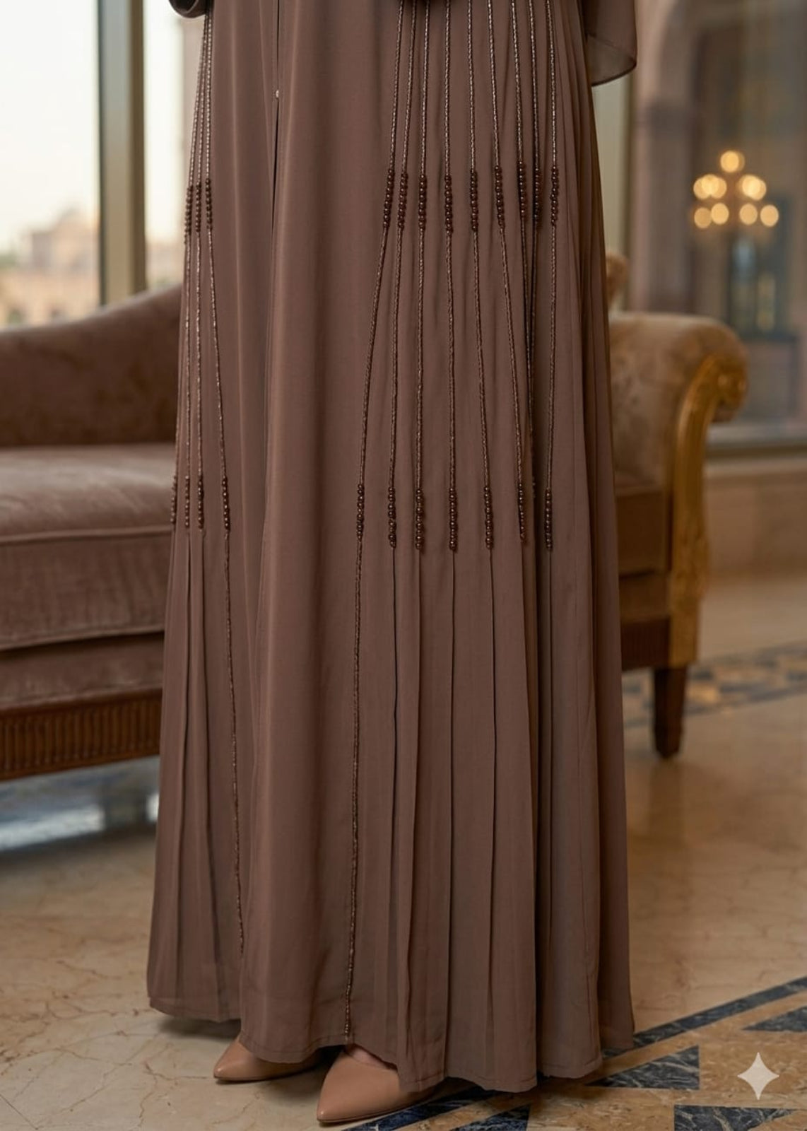 Brown dress with bead details on a patterned floor
